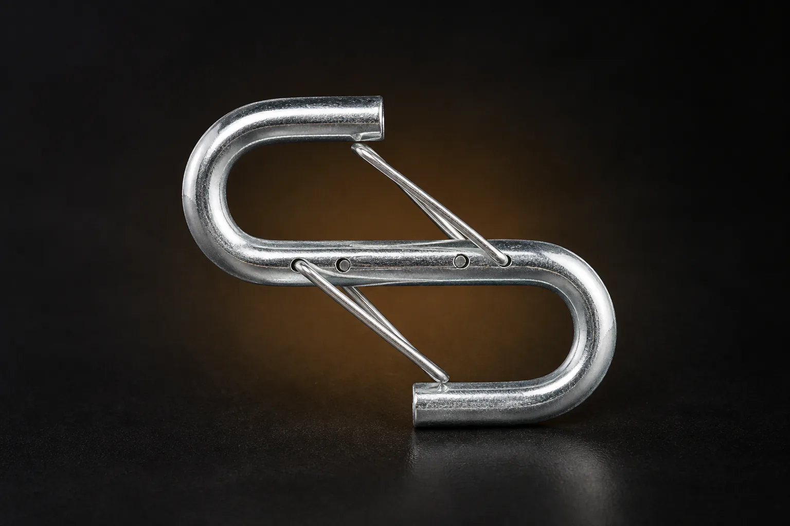 Two linked galvanized-steel wire-gate hooks on a dark studio background